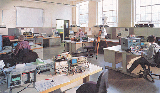 Two students and a tutor in a lab with electronic equipment